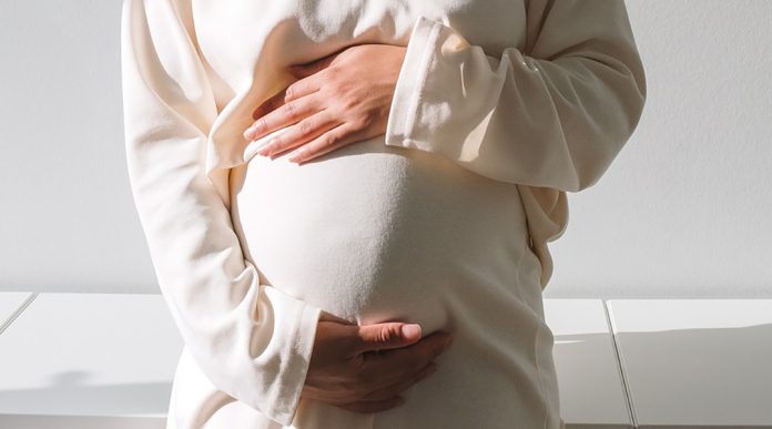 Pregnant woman holding her belly.